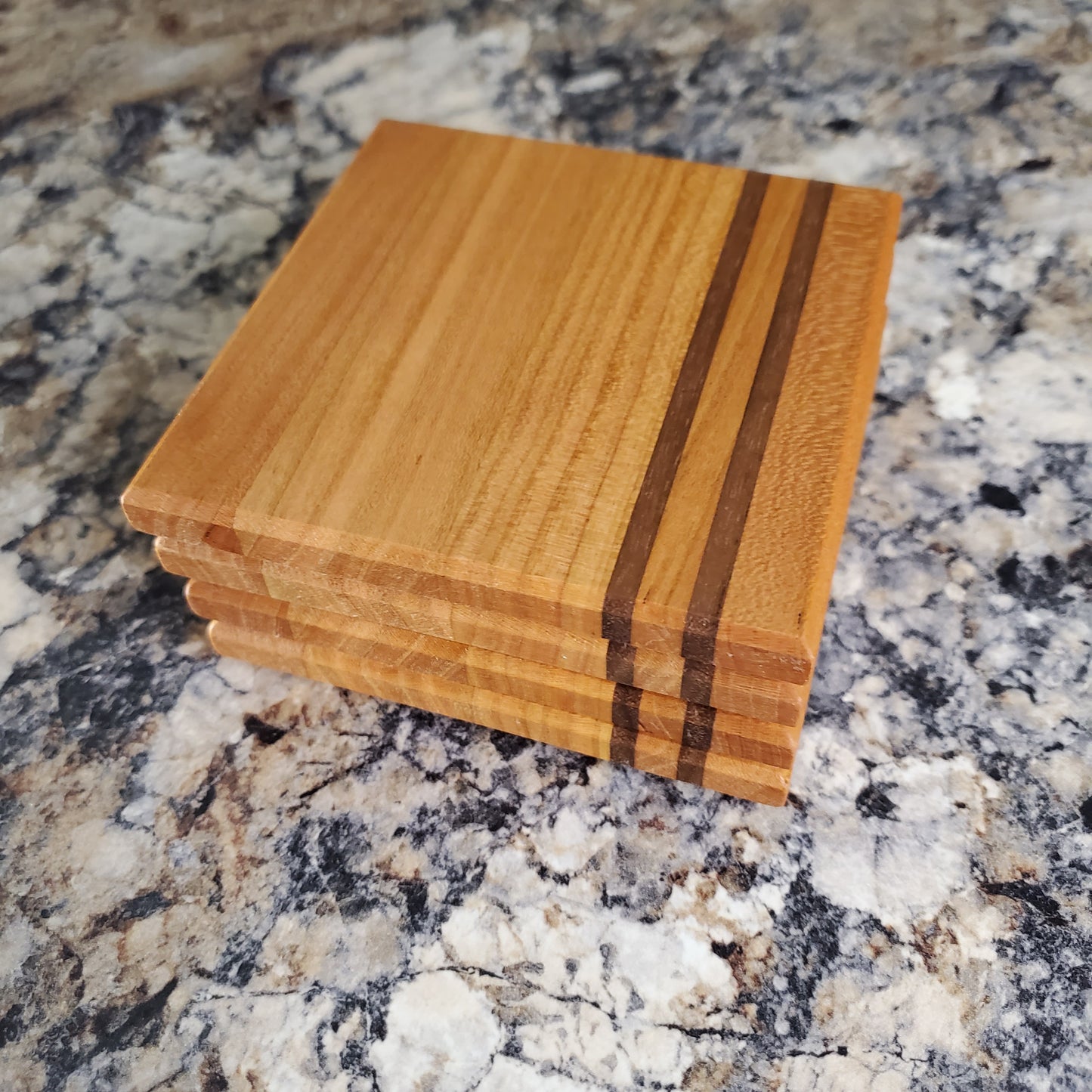 Classic coasters, made of primarily cherry with two walnut stripes by Lone Wolf Wood Designs
