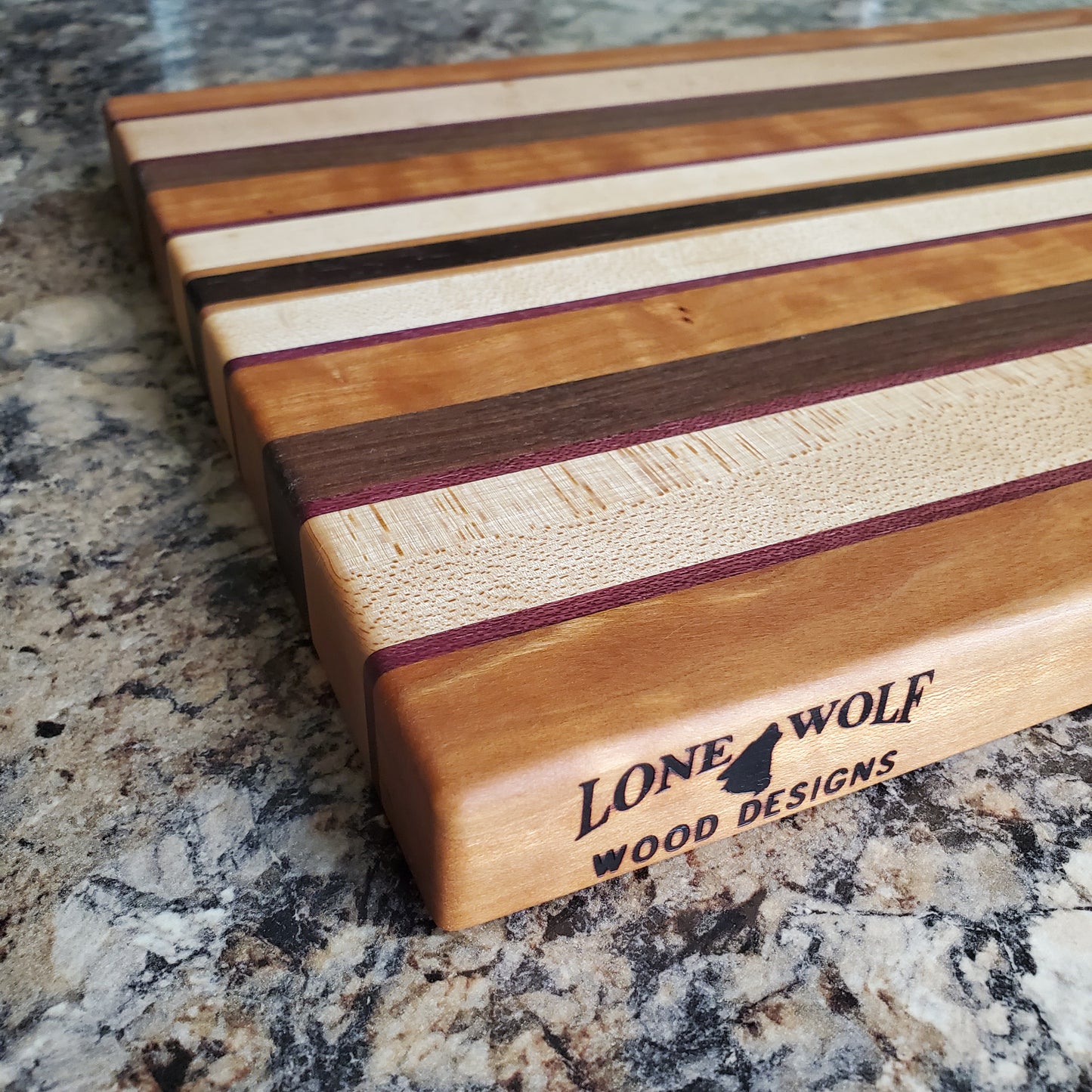Signature Series Peekaboo cutting board made from maple, walnut, cherry, purple heart, and wenge by Lone Wolf Wood Designs