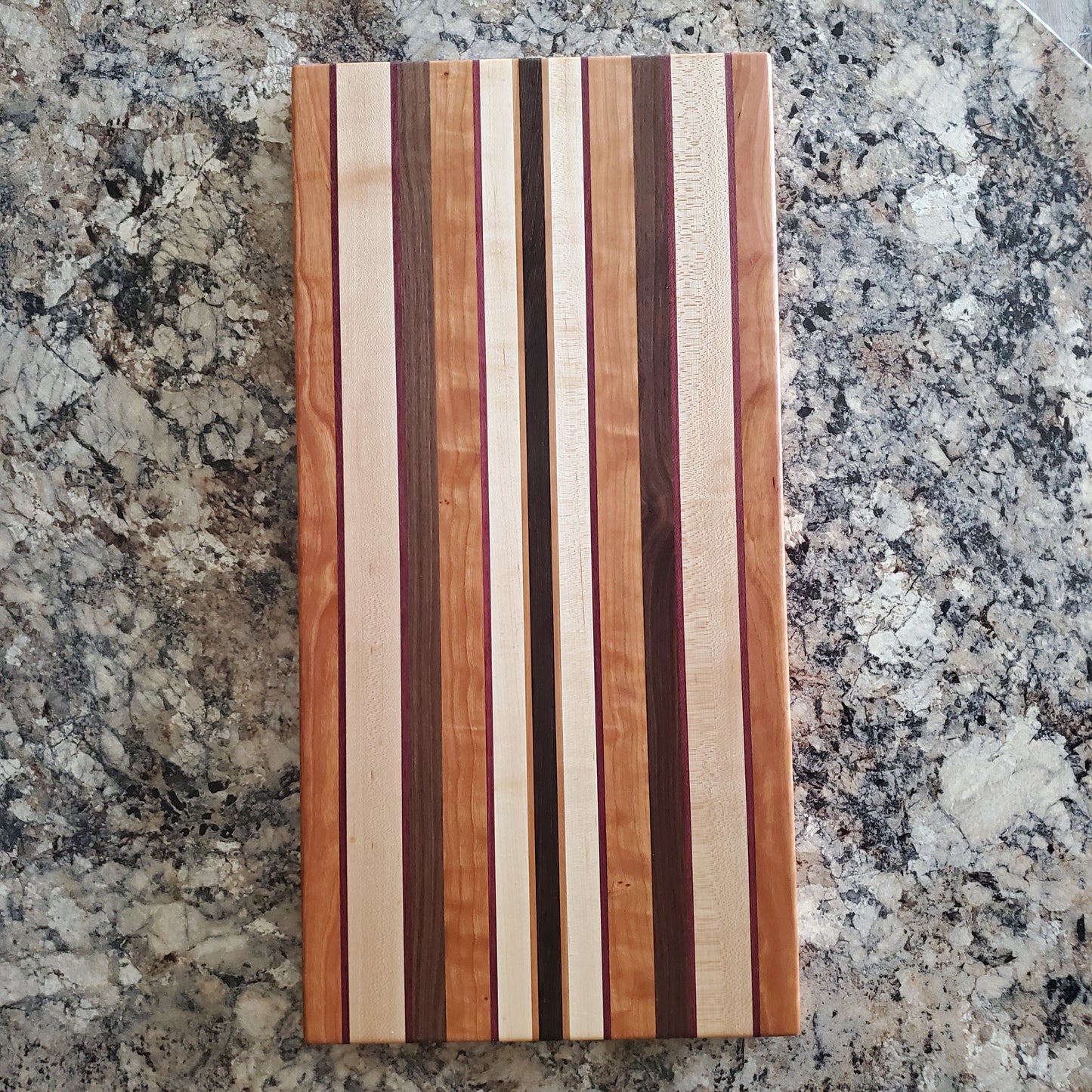 Signature Series Peekaboo cutting board made from maple, walnut, cherry, purple heart, and wenge by Lone Wolf Wood Designs