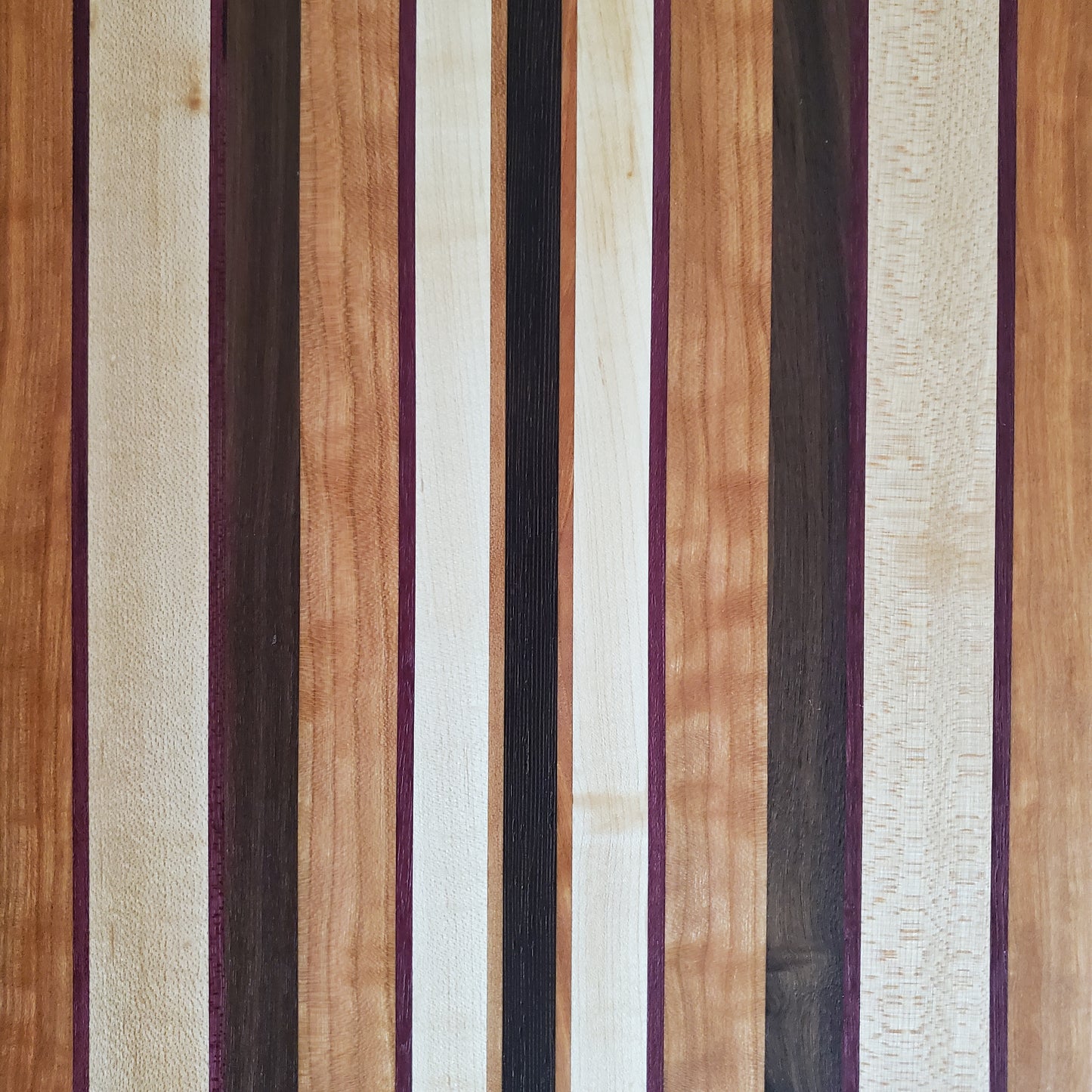 Signature Series Peekaboo cutting board made from maple, walnut, cherry, purple heart, and wenge by Lone Wolf Wood Designs