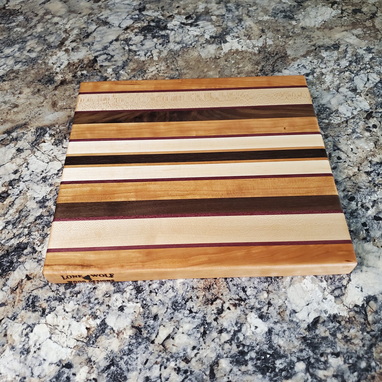 Signature Series Peekaboo cutting board made from maple, walnut, cherry, purple heart, and wenge by Lone Wolf Wood Designs