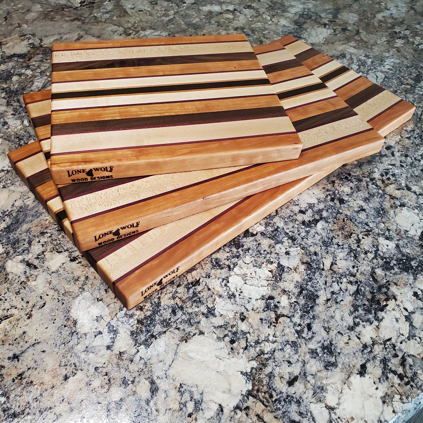 Signature Series Peekaboo cutting board made from maple, walnut, cherry, purple heart, and wenge by Lone Wolf Wood Designs