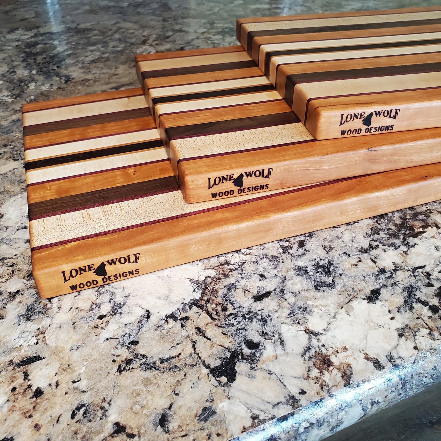 Signature Series Peekaboo cutting board made from maple, walnut, cherry, purple heart, and wenge by Lone Wolf Wood Designs
