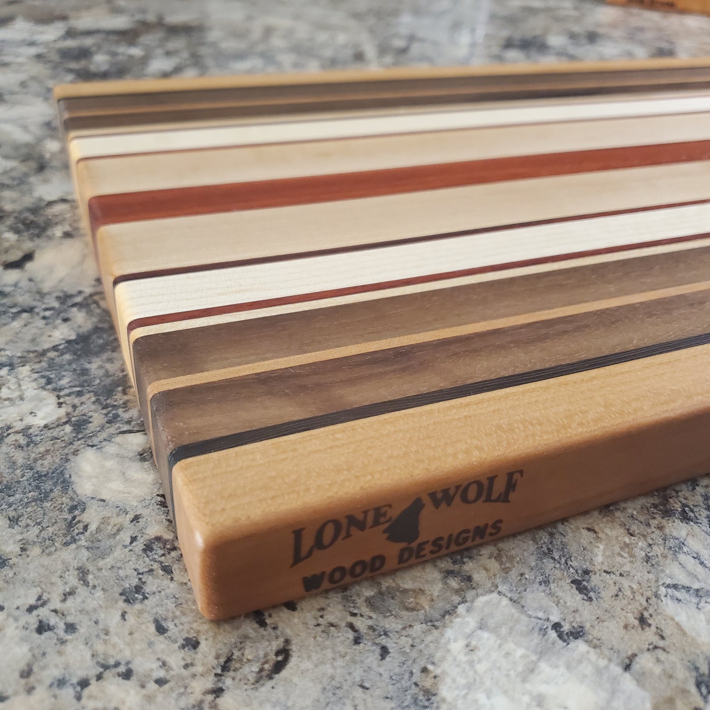Signature Series Pumpkin Spice cutting board made from maple, walnut, cherry, padauk, and wenge by Lone Wolf Wood Designs