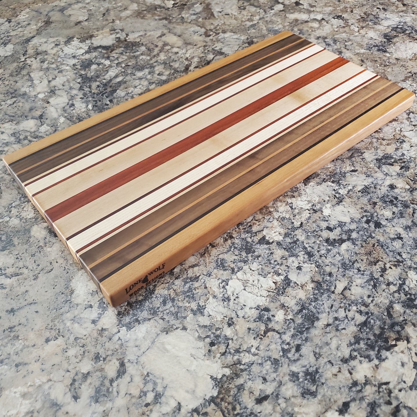 Signature Series Pumpkin Spice cutting board made from maple, walnut, cherry, padauk, and wenge by Lone Wolf Wood Designs