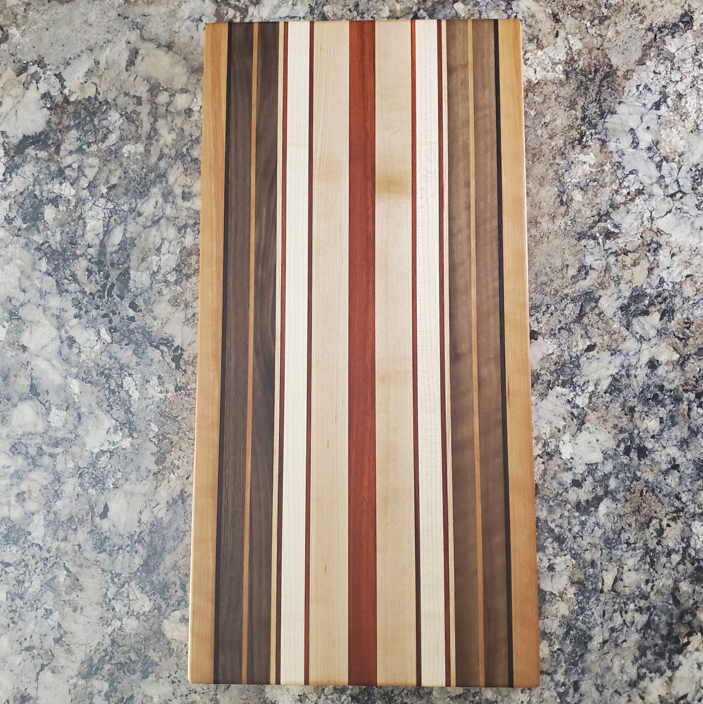 Signature Series Pumpkin Spice cutting board made from maple, walnut, cherry, padauk, and wenge by Lone Wolf Wood Designs