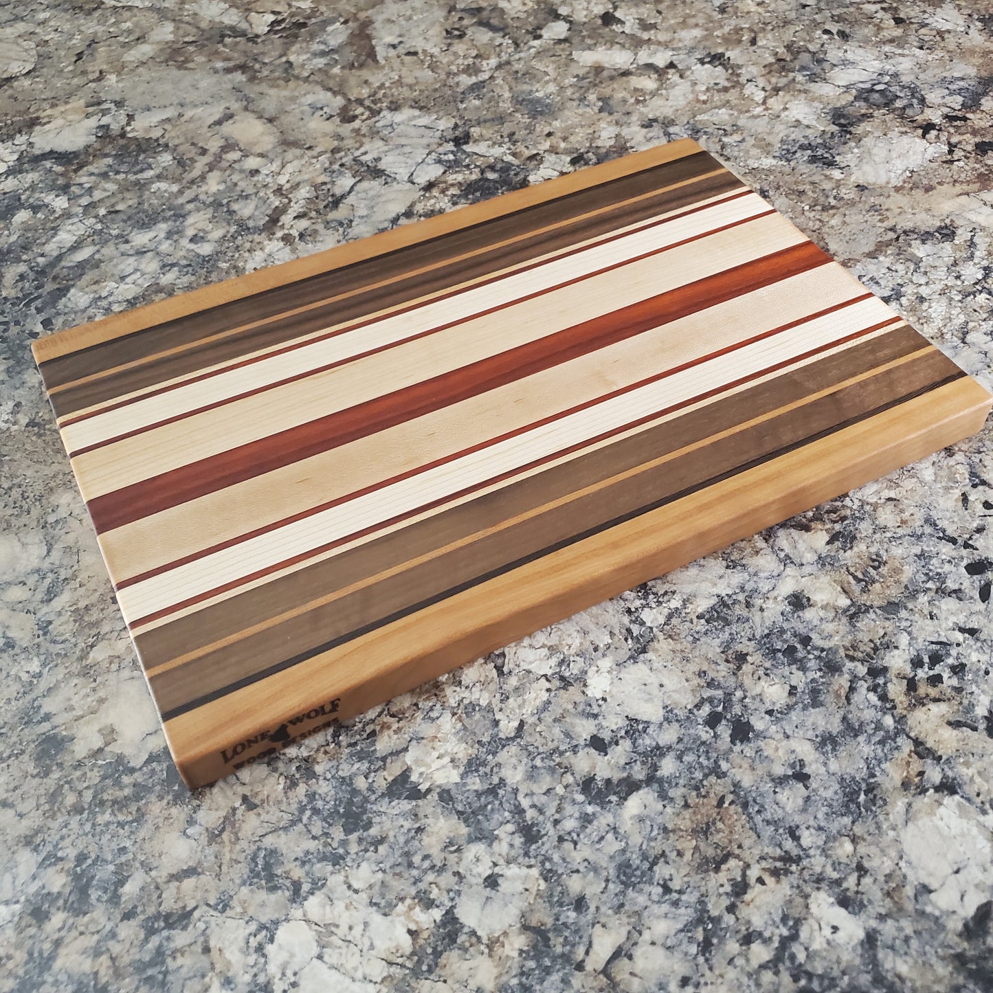 Signature Series Pumpkin Spice cutting board made from maple, walnut, cherry, padauk, and wenge by Lone Wolf Wood Designs