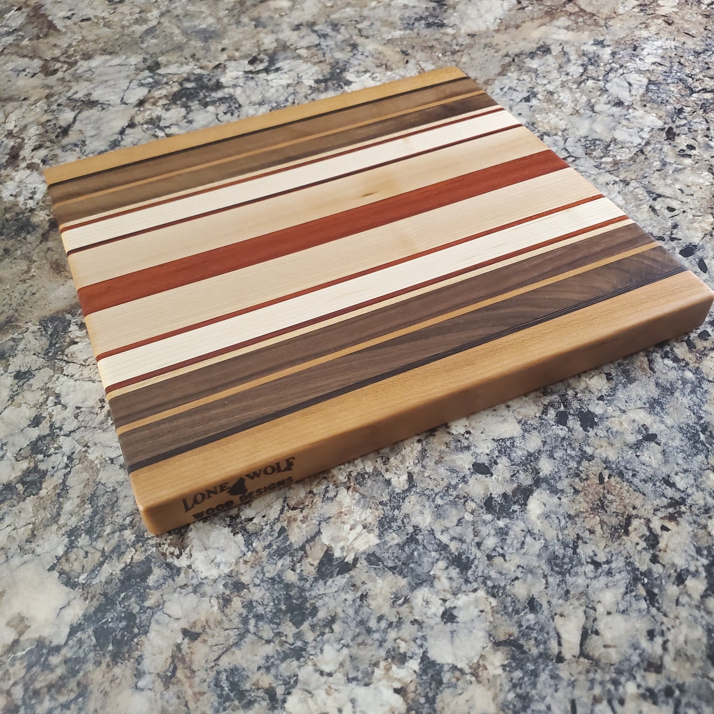 Signature Series Pumpkin Spice cutting board made from maple, walnut, cherry, padauk, and wenge by Lone Wolf Wood Designs