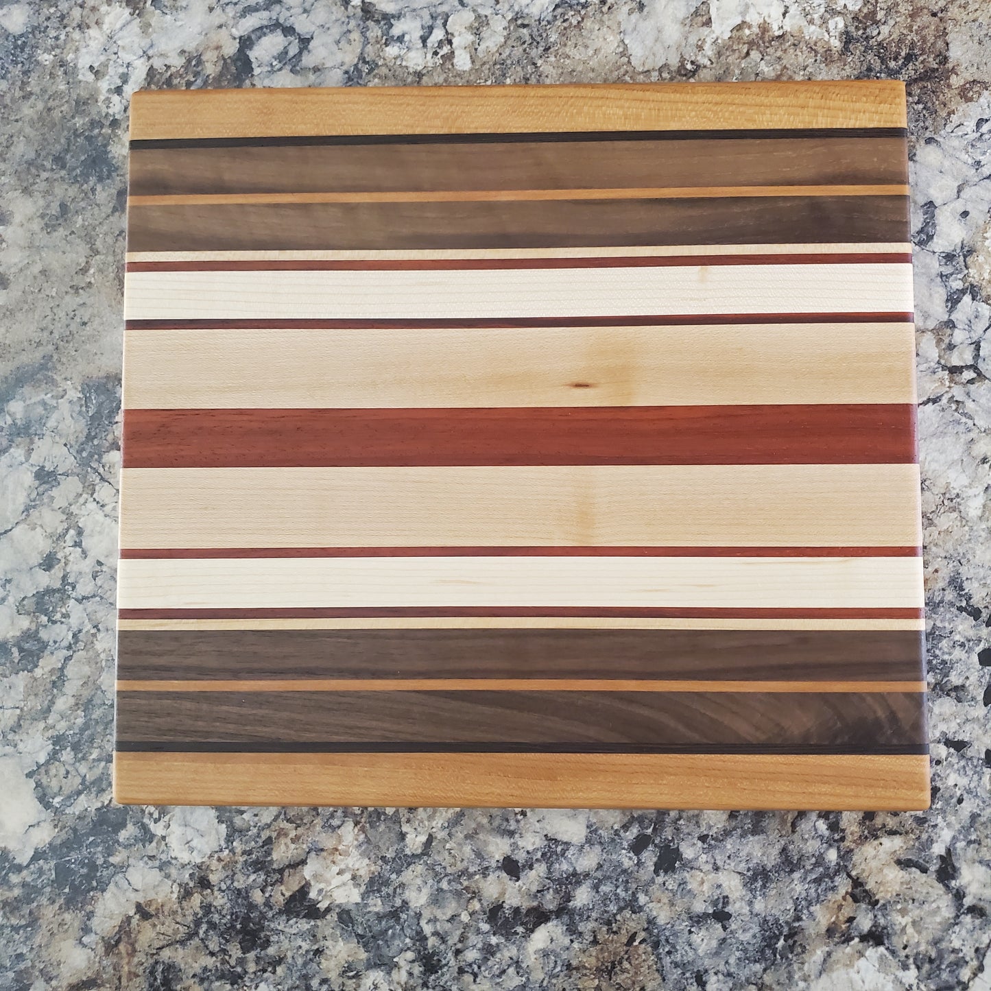 Signature Series Pumpkin Spice cutting board made from maple, walnut, cherry, padauk, and wenge by Lone Wolf Wood Designs