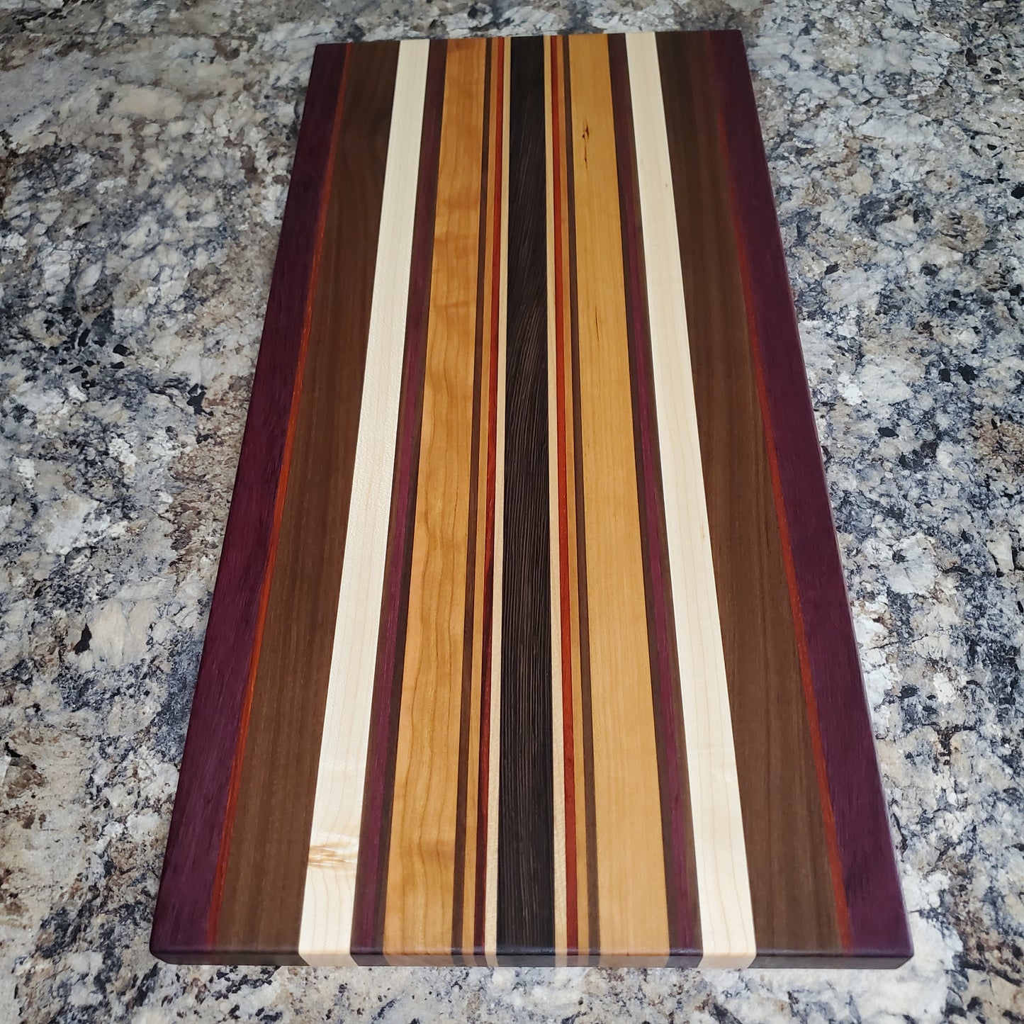 Signature Series Royalty cutting board made from maple, walnut, cherry, padauk, purple heart, and wenge by Lone Wolf Wood Designs