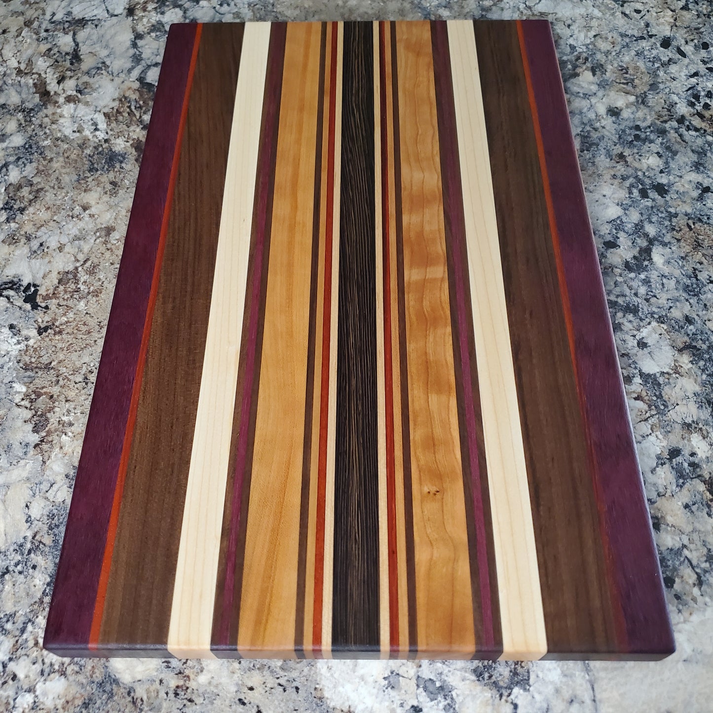 Signature Series Royalty cutting board made from maple, walnut, cherry, padauk, purple heart, and wenge by Lone Wolf Wood Designs