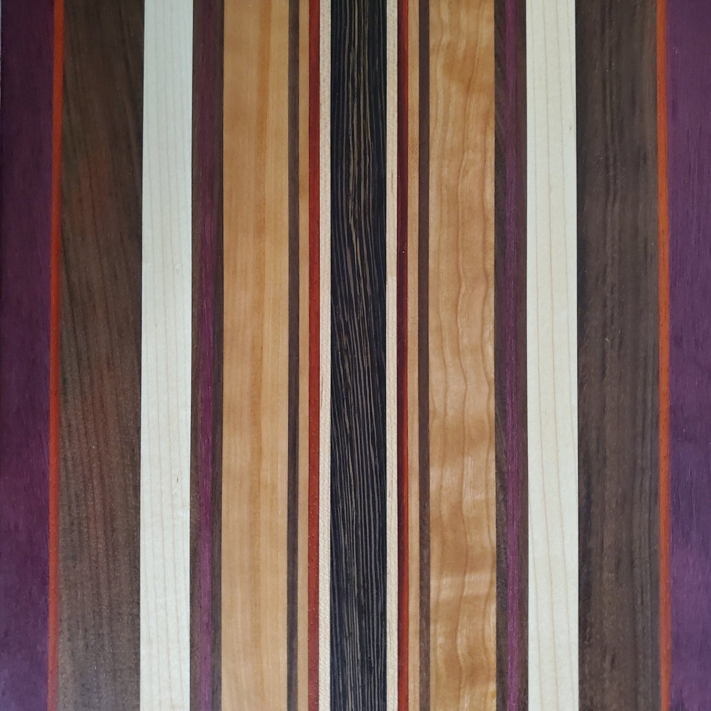 Signature Series Royalty cutting board made from maple, walnut, cherry, padauk, purple heart, and wenge by Lone Wolf Wood Designs
