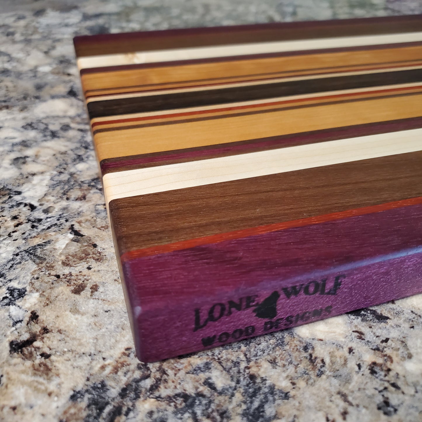 Signature Series Royalty cutting board made from maple, walnut, cherry, padauk, purple heart, and wenge by Lone Wolf Wood Designs