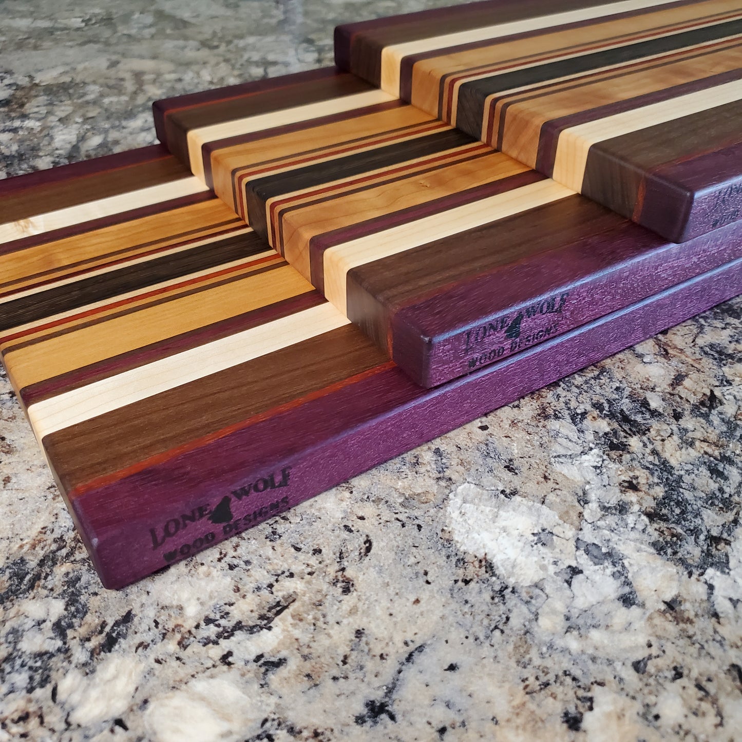 Signature Series Royalty cutting board made from maple, walnut, cherry, padauk, purple heart, and wenge by Lone Wolf Wood Designs