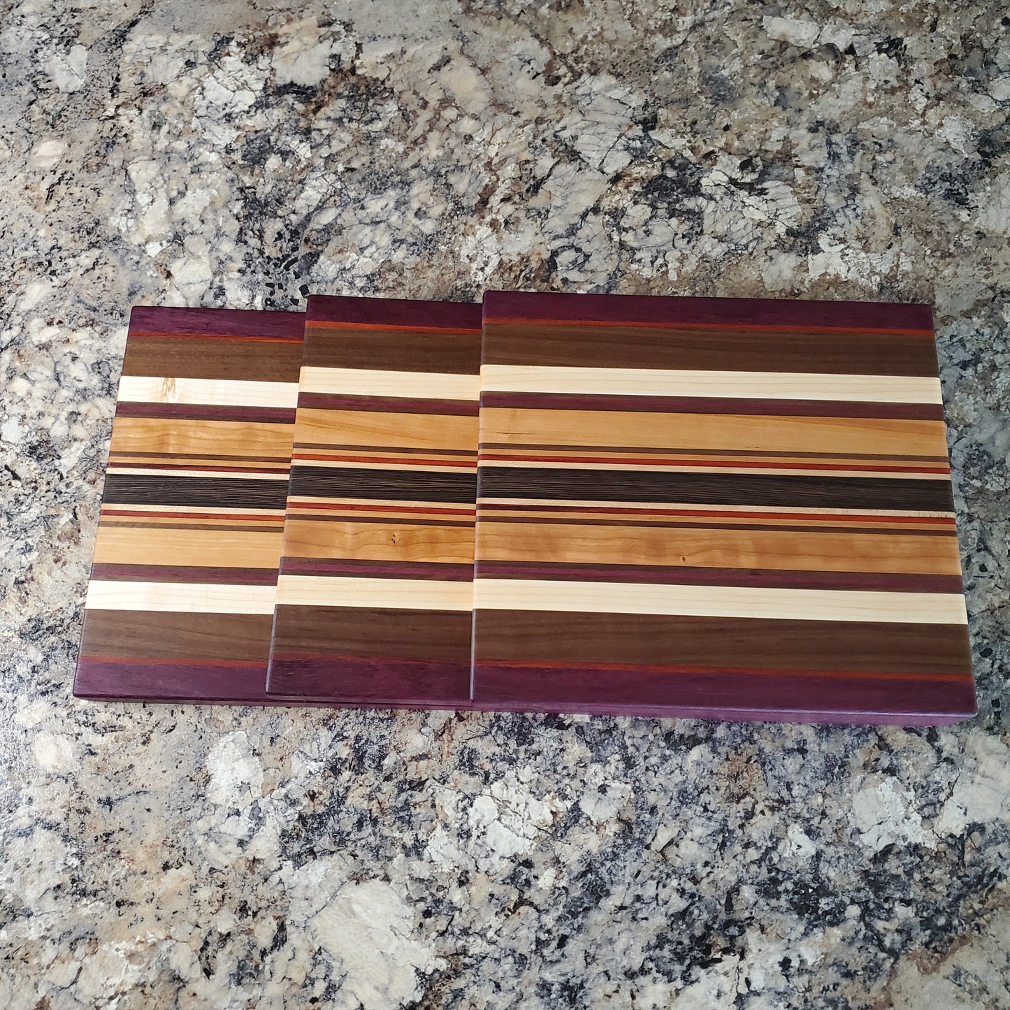 Signature Series Royalty cutting board made from maple, walnut, cherry, padauk, purple heart, and wenge by Lone Wolf Wood Designs