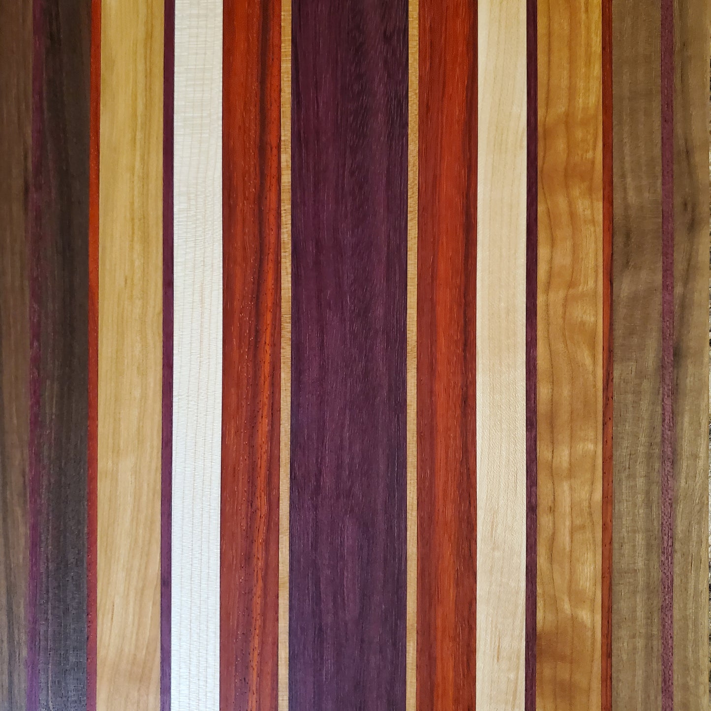 Signature Series Sunset cutting board made from walnut, cherry, maple, purple heart, and padauk by Lone Wolf Wood Designs