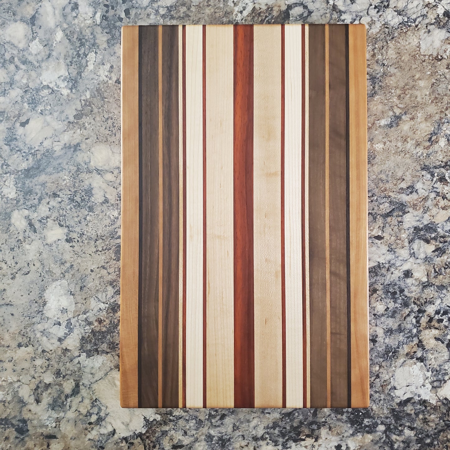 Signature Series Pumpkin Spice cutting board made from maple, walnut, cherry, padauk, and wenge by Lone Wolf Wood Designs