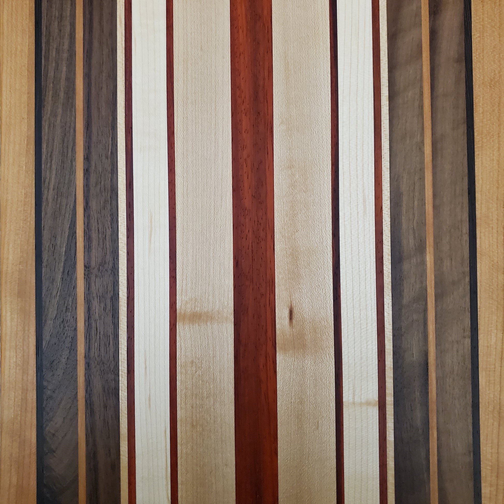Signature Series Pumpkin Spice cutting board made from maple, walnut, cherry, padauk, and wenge by Lone Wolf Wood Designs