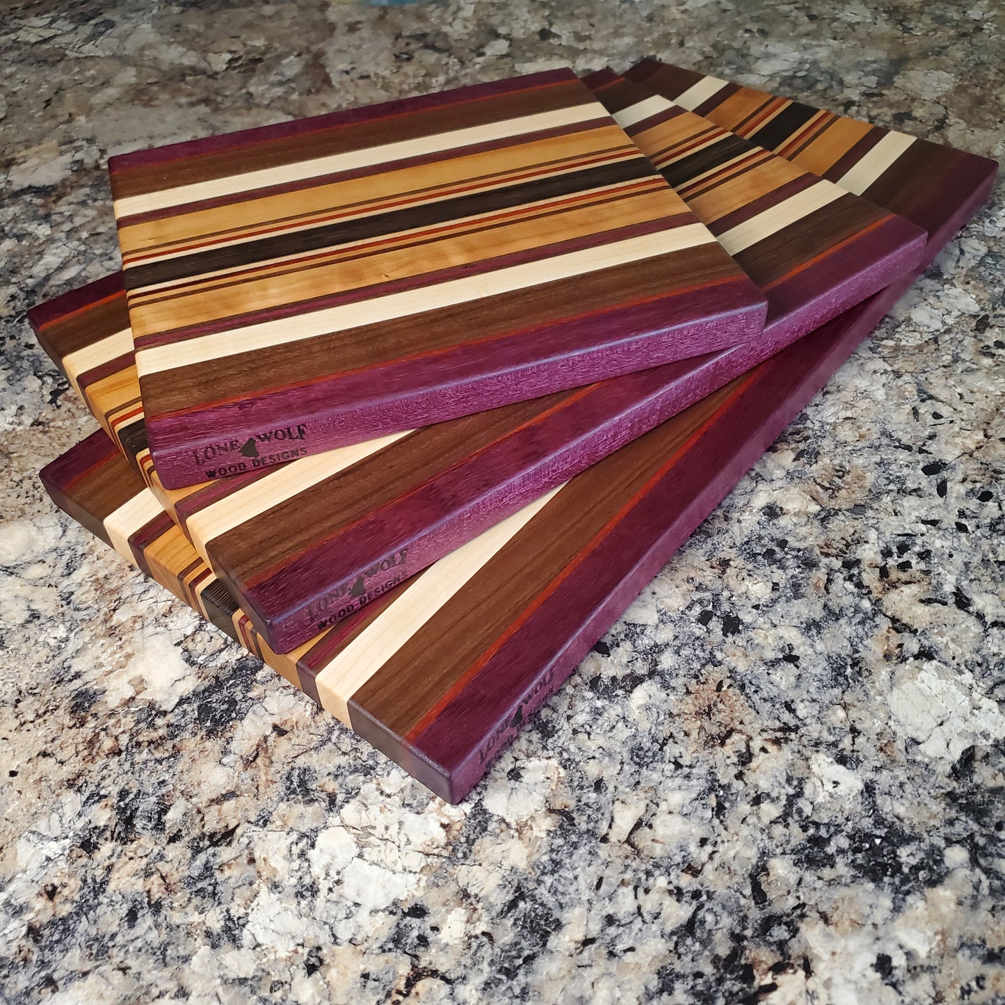 Signature Series Royalty cutting board made from maple, walnut, cherry, padauk, purple heart, and wenge by Lone Wolf Wood Designs