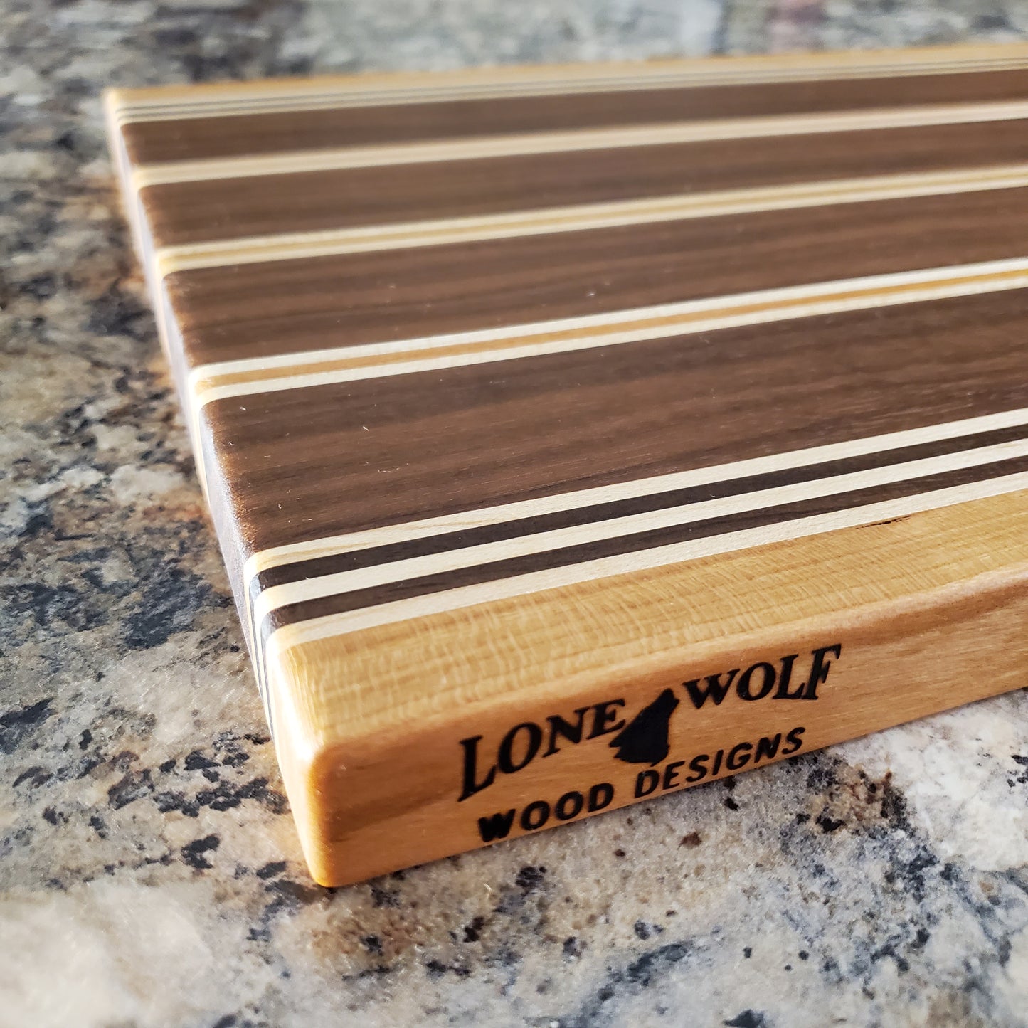 Signature Series Rushmore cutting board made from maple, walnut, and cherry by Lone Wolf Wood Designs