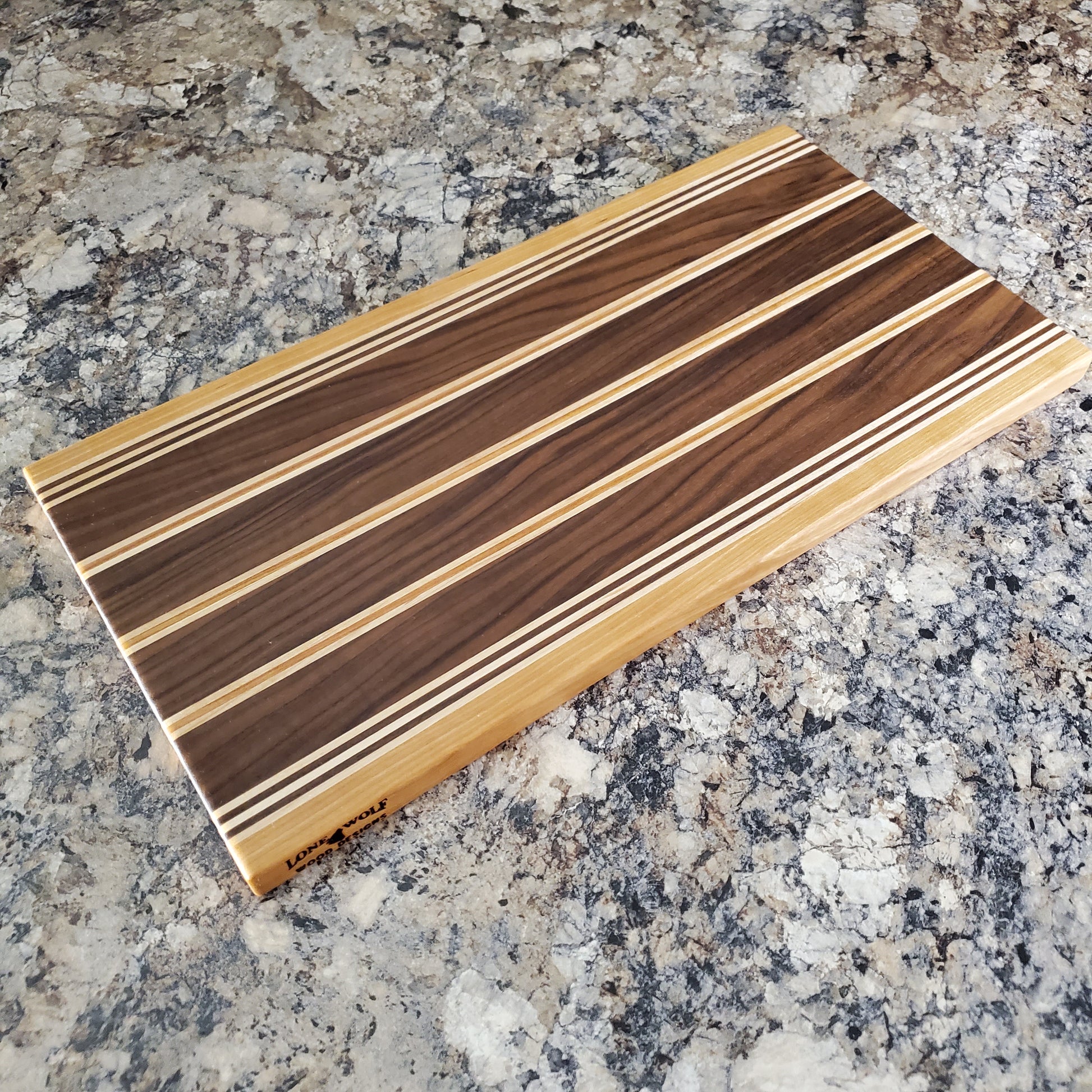 Signature Series Rushmore cutting board made from maple, walnut, and cherry by Lone Wolf Wood Designs