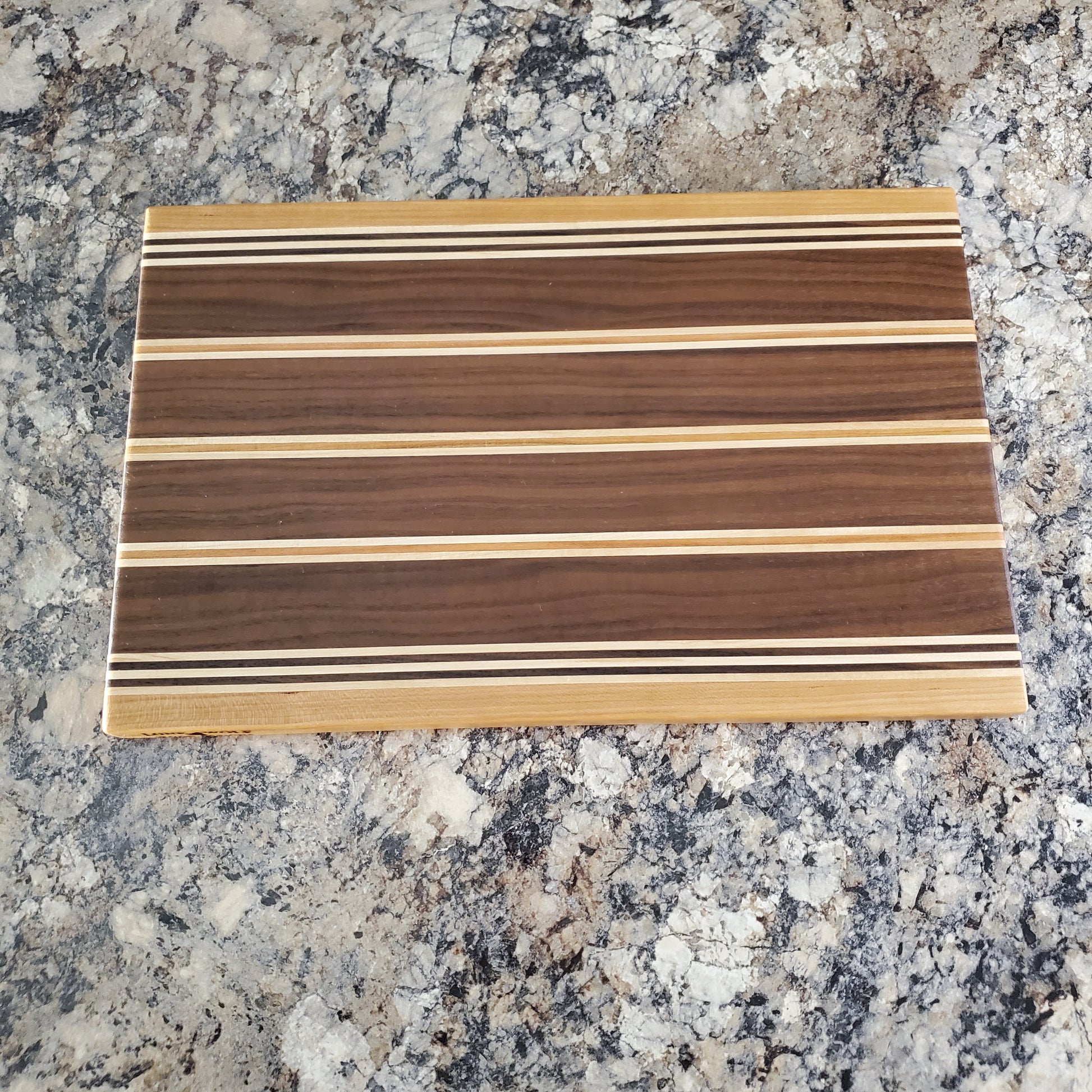 Signature Series Rushmore cutting board made from maple, walnut, and cherry by Lone Wolf Wood Designs