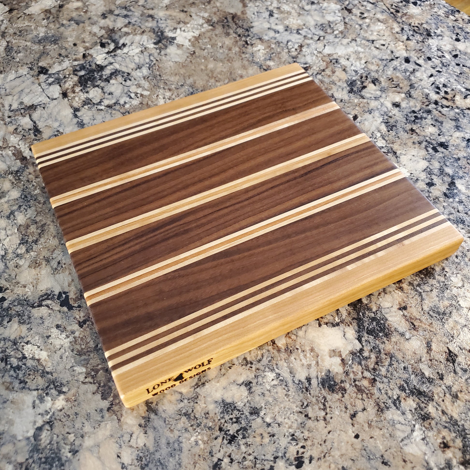 Signature Series Rushmore cutting board made from maple, walnut, and cherry by Lone Wolf Wood Designs