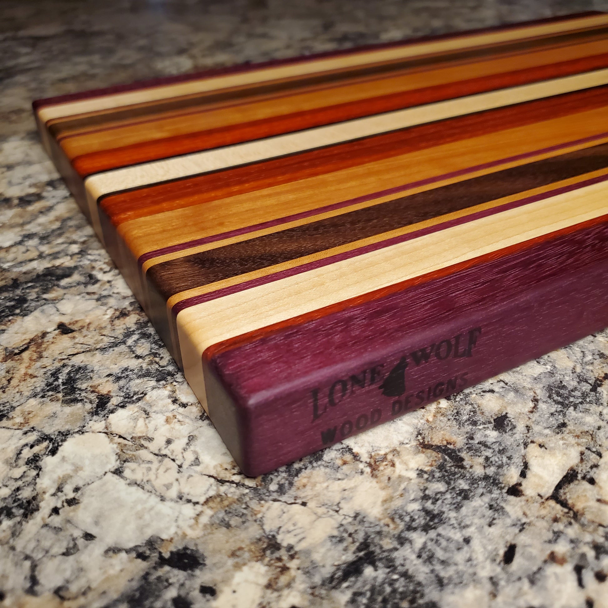 Signature Series Tiger Lily cutting board made from walnut, cherry, maple, purple heart, wenge, and padauk by Lone Wolf Wood Designs