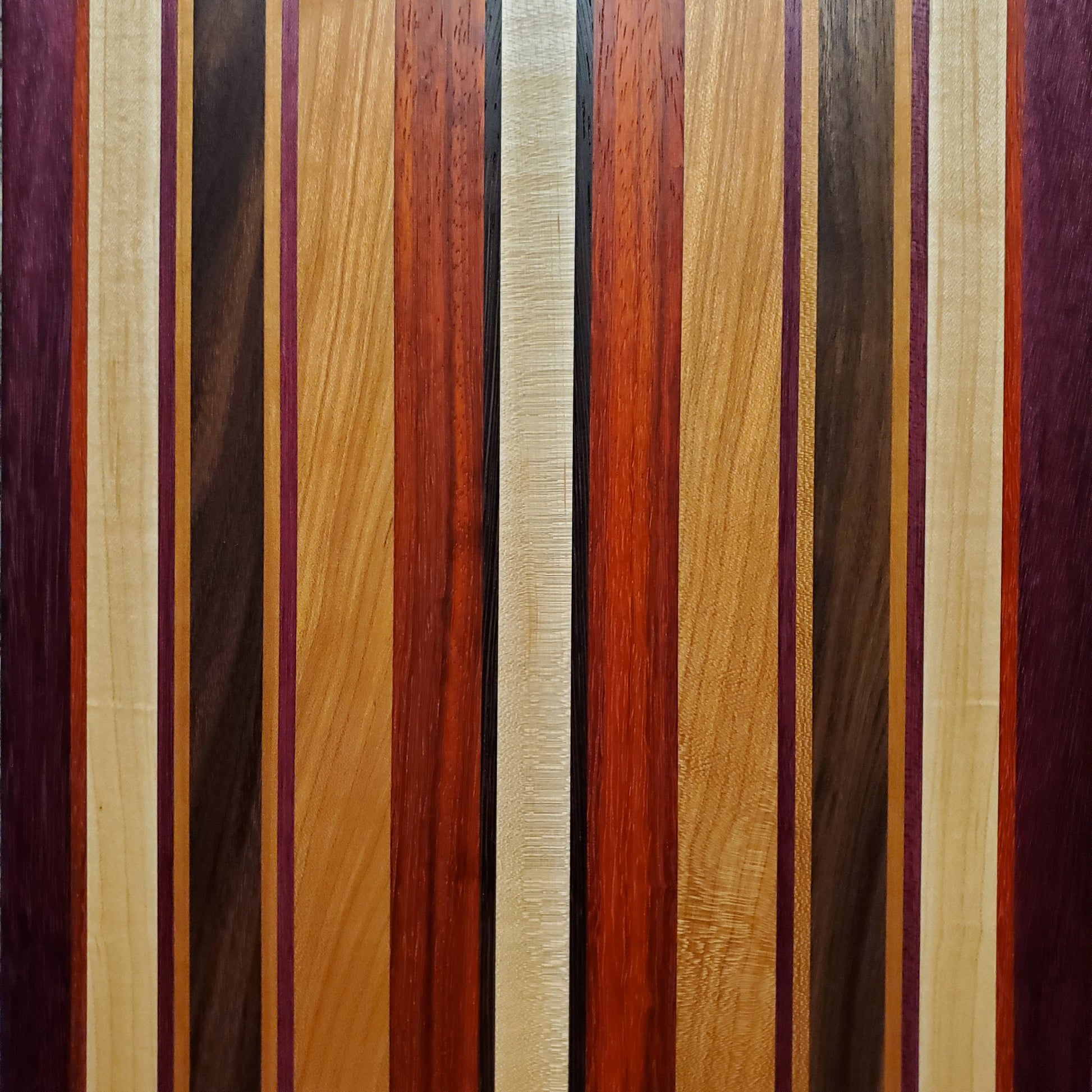 Signature Series Tiger Lily cutting board made from walnut, cherry, maple, purple heart, wenge, and padauk by Lone Wolf Wood Designs